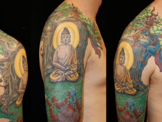 beautiful colorful portrait of bodha under bodhi tree tattoo on men sleeve shoulder