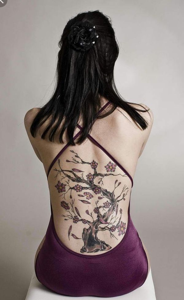 gorgeous lower back female bodhi tree tattoo with pink flowers