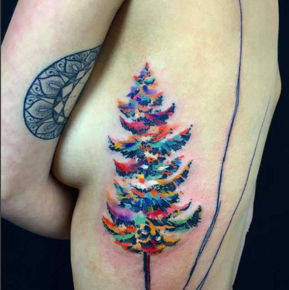 big watercolor evergreen tree tattoo on side ribs for women