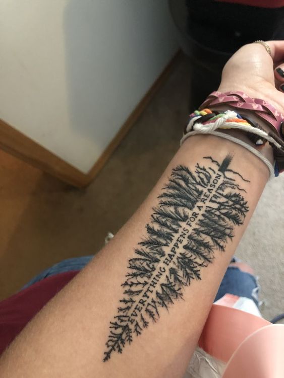evergreen tree with quote everything happens for a reason tattoo on wrist