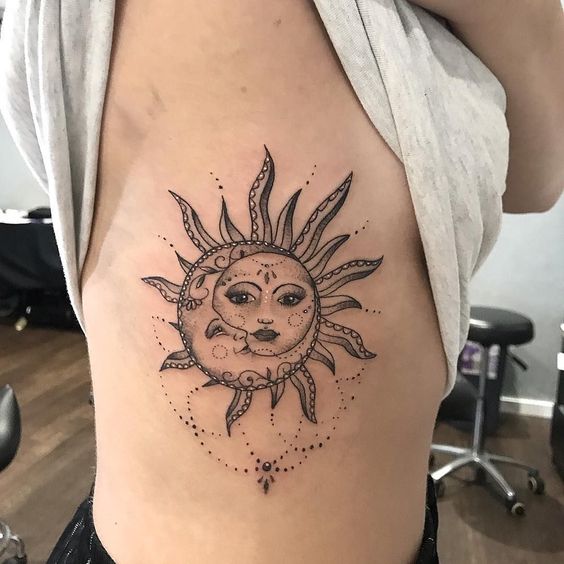 sun and moon tattoo design on side ribs with chandeliers