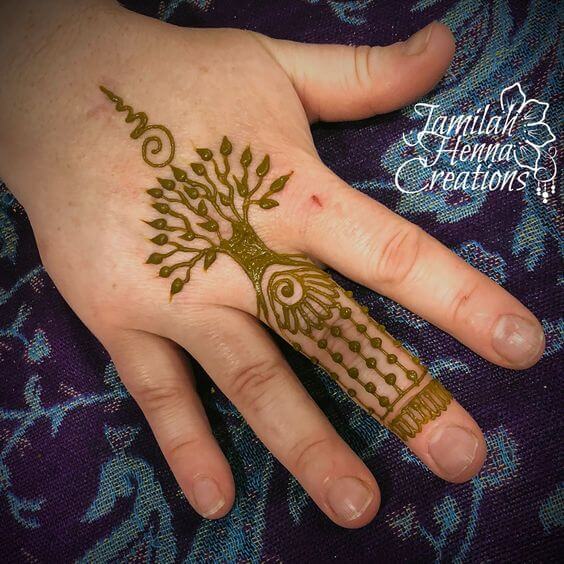 tree of life with unalome henna design on middle finger