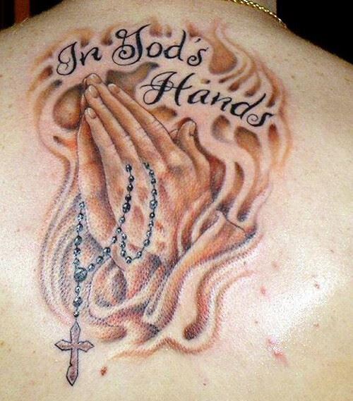 in gods hands script tattoo design with praying hands and rosary-cross in fire on back shoulder