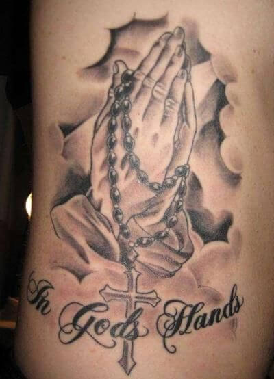 in gods hands tattoo with clouds and praying hands with rosary-cross for god to forgive