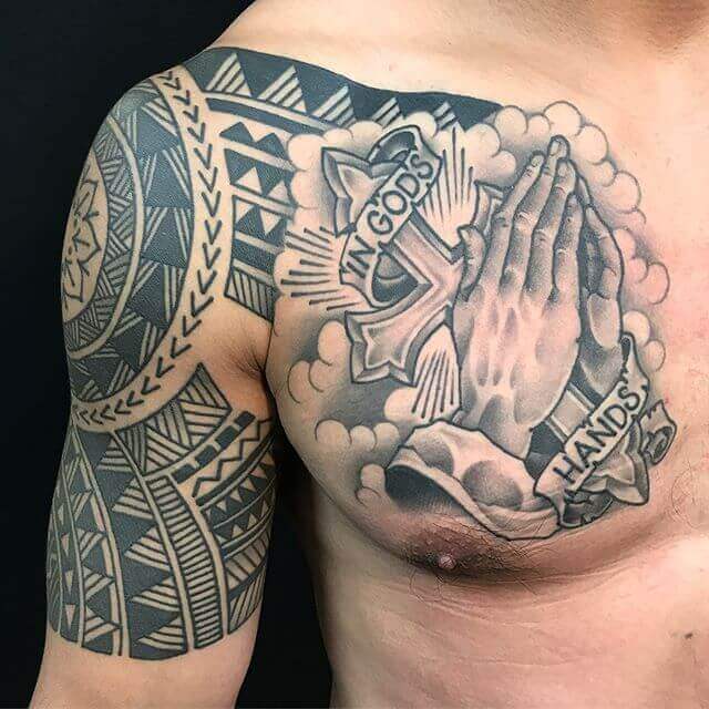 in gods hands banner tattoo with clouds and cross with tribal aztec design on chest shoulder
