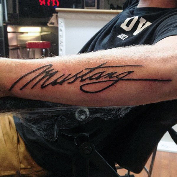 mustang script font tattoo on arm