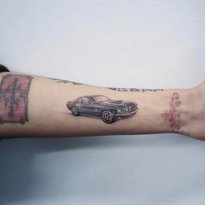 small ford mustang tattoo on forearm