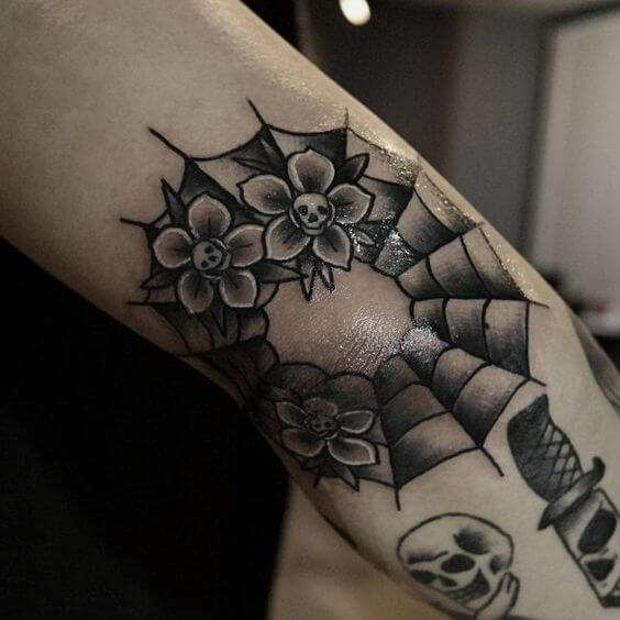 small floral spider web tattoo design on elbow