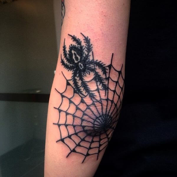 small spider web elbow tattoo